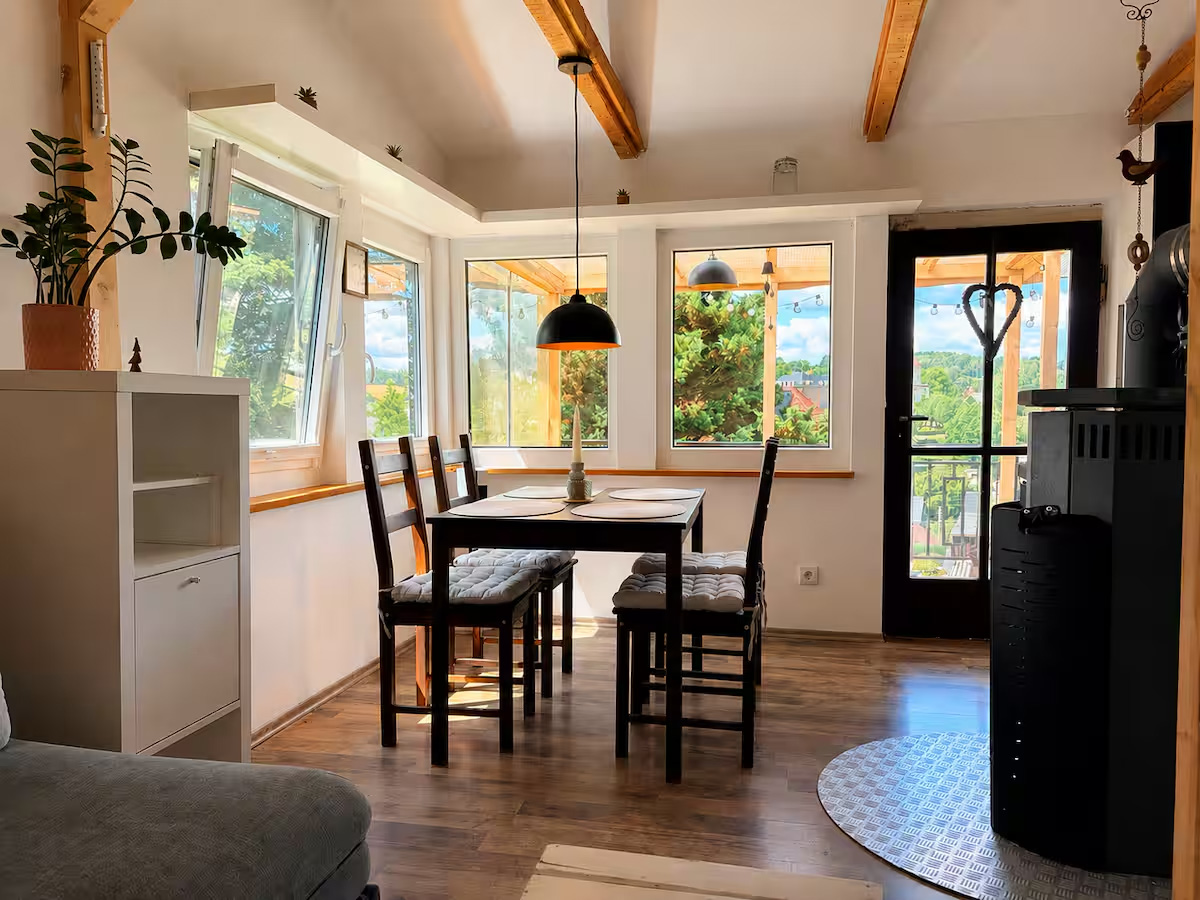 Heller Wohn- und Essbereich der Ferienwohnung mit Blick ins Grüne